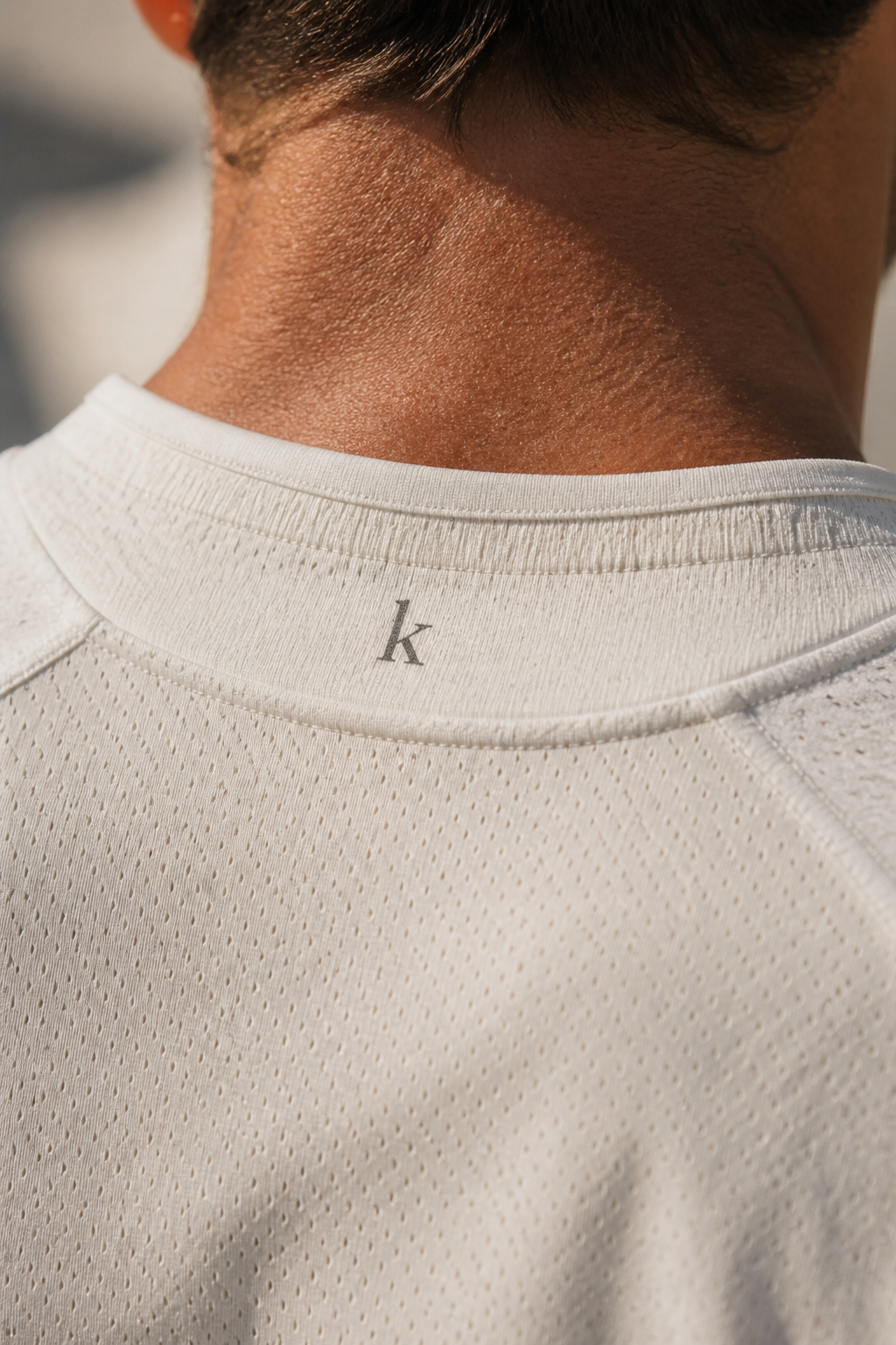 Tiny lowercase k at the back collar. k at the nape.